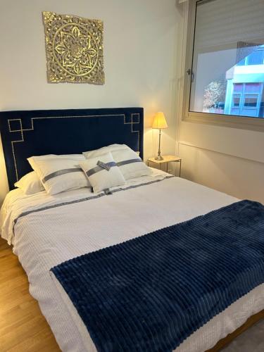 a bedroom with a blue and white bed with a window at Appartement central in Toulouse