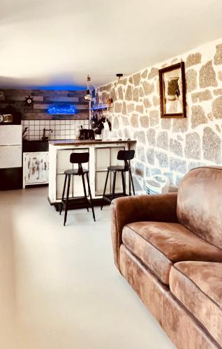 un salon avec un canapé et un mur en pierre dans l'établissement La cave marine du Trottel, à Ajaccio