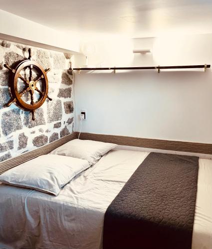 Ce lit se trouve dans un dortoir doté d'une horloge murale. dans l'établissement La cave marine du Trottel, à Ajaccio