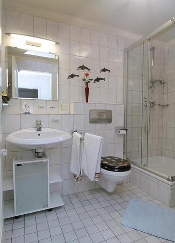 a bathroom with a sink and a toilet and a shower at Ferienwohnung Brigitte Leist in Sankt Wendel