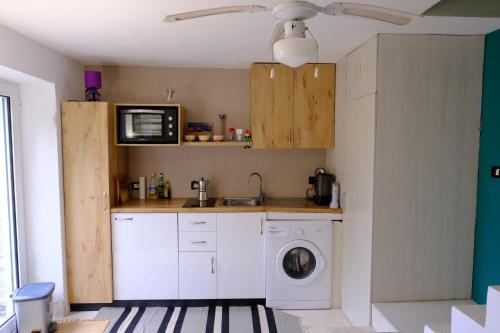 a kitchen with a washing machine and a microwave at Les Villas de Qeparo in Qeparo