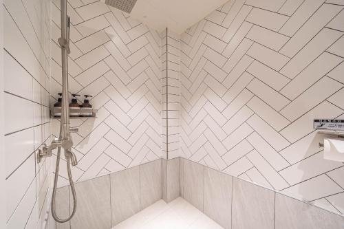 a bathroom with a shower with white tiles at HOTEL STAY AYANA DAEJEON in Daejeon