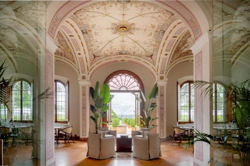 um quarto ornamentado com um tecto com um lustre em Precise Tale Poggio Alla Sala em Montepulciano