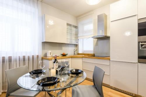 una sala da pranzo con tavolo in vetro e sedie di Nr 1 EUROPA22 CENTRUM Apartment OLD TOWN Warsaw STARE MIASTO Historyczna kamienica umiejscowiona w zabytkowej części Warszawy PARKING 24h Śniadanie opcjonalnie Breakfast optional Check in from 13 pm PARTER a Varsavia