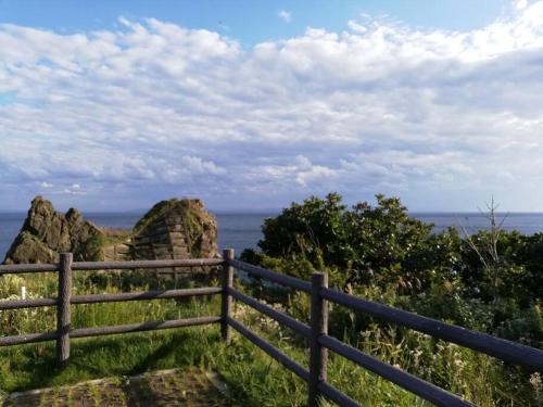 a fence on the edge of a cliff overlooking the ocean at 854Annex in Kotaniishi