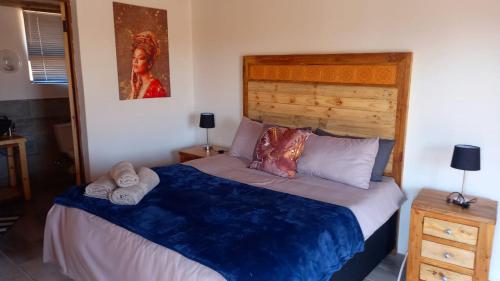 a bedroom with a large bed with a wooden headboard at FLY FISHING PARADISE ON THE VAAL in Parys