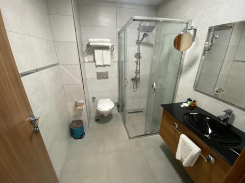 uma casa de banho com uma cabina de duche em vidro e um lavatório. em İNNPORT HOTEL em Gebze