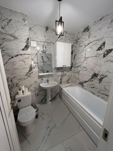a bathroom with a sink and a toilet and a bath tub at Luxury Apartments and Studios Boulevard G Enescu Suceava in Suceava