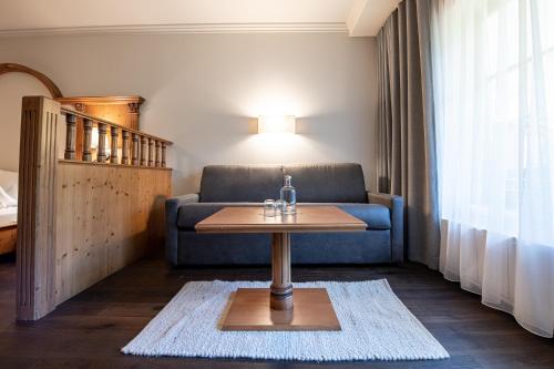 a living room with a couch and a table at Naturhotel MOLIN in San Giovanni in Val Aurina