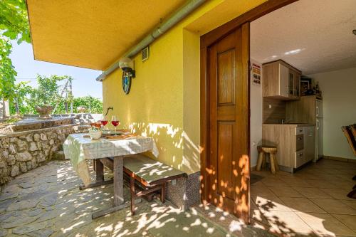 a patio with a table and a kitchen in a house at Vineyard Cottage Hočevar With Sauna - Happy Rentals in Novo Mesto