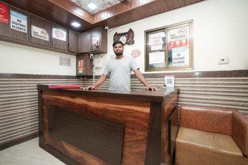 un hombre parado detrás de un mostrador en un restaurante en Hotel Mumbai Residency, en Bombay