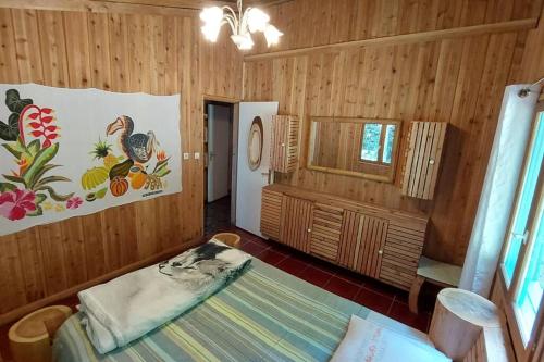 Zimmer mit Holzwänden und einem Bett in einem Zimmer in der Unterkunft Ma cabane à Cilaos in Cilaos