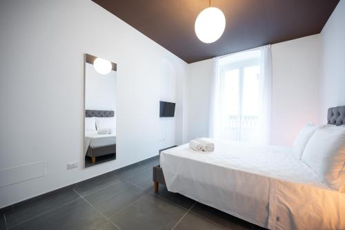 a white bedroom with a bed and a mirror at Porta Nuova Luxury Apartments in Turin
