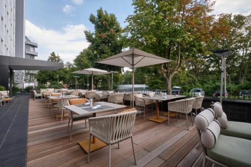 ein Restaurant im Freien mit Tischen, Stühlen und Sonnenschirmen in der Unterkunft AC Hotel by Marriott Berlin Humboldthain Park in Berlin