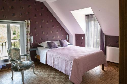 a bedroom with a bed and a chair and a window at Holistica - Bien être in Saint-Fargeau