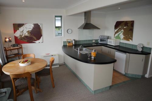 a kitchen with a table and a counter top at Absolutely in Kaikoura