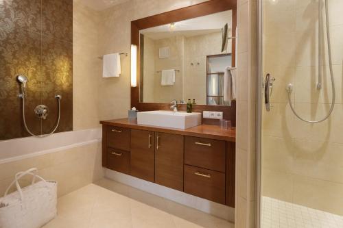 a bathroom with a sink and a shower at Naturhotel MOLIN in San Giovanni in Val Aurina