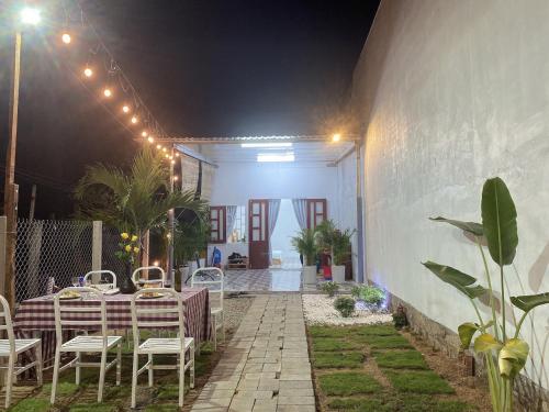 a patio with a table and chairs at night at Nại Home Venuestay in Ninh Hải