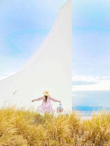 a woman in a hat standing in front of a surfboard at DoubleTree by Hilton Shanwei in Shanwei