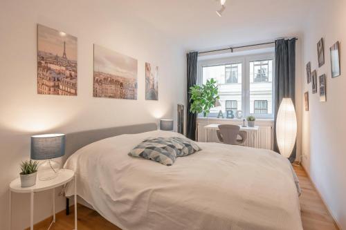 a white bedroom with a bed and a window at Modern City Center Apartment in Vienna