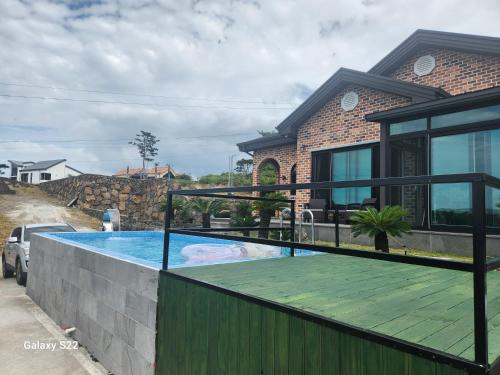 a swimming pool in the backyard of a house at Sunshine Aewol Entire House in Jeju