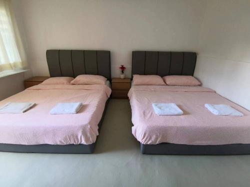 two beds sitting next to each other in a room at Moonriver Lodge in Cameron Highlands