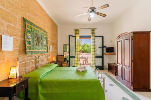 a bedroom with a green bed and a ceiling fan at Domus mea salento Arazzo Verde in Ugento