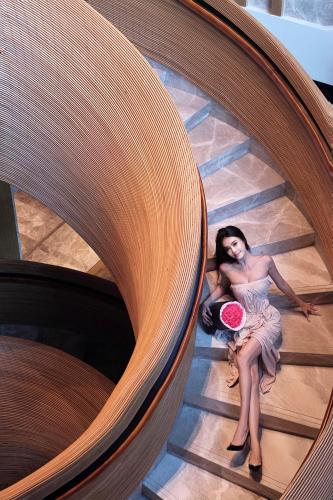 a woman in a dress sitting on the stairs at DoubleTree by Hilton Shanwei in Shanwei