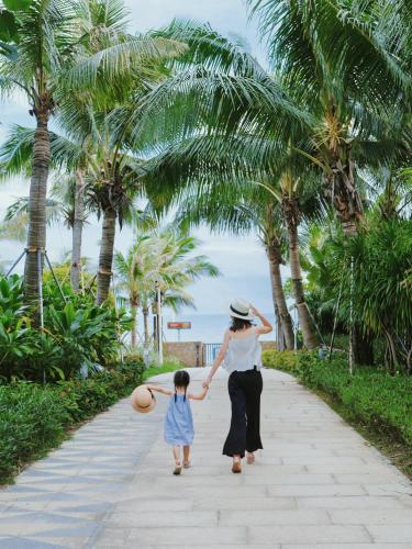 a woman and a little girl walking down a sidewalk at DoubleTree by Hilton Shanwei in Shanwei