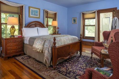 - une chambre avec un lit, une chaise et des fenêtres dans l'établissement Historic House! 12 acres 6 Suites BBQ, à Candler