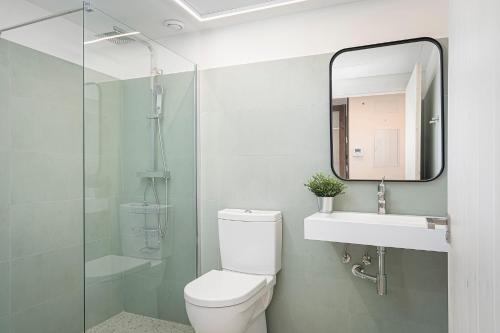 y baño con aseo, lavabo y espejo. en Benaki 85 Apartamento en plena naturaleza, 