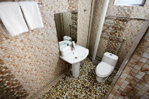 een badkamer met een toilet, een wastafel en een douche bij KZO Hotel in Simkent