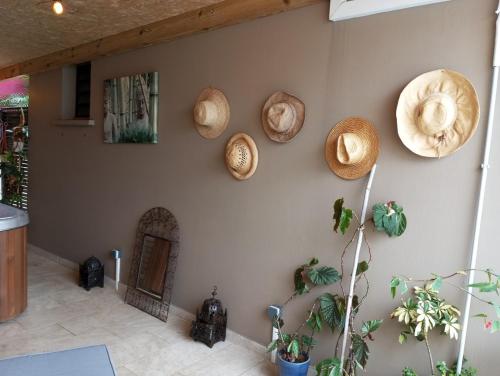 a room with a wall with straw hats on it at NON FUMEURS uniquement ! LIRE PROFIL DE L'HOTE AVANT DE RESERVER! in Saint-Pierre