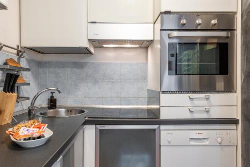 a kitchen with white cabinets and a sink at Giudice Donadoni, 12 - Università e svago in Milan