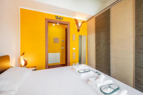a bedroom with a white bed and a yellow wall at Giudice Donadoni, 12 - Università e svago in Milan