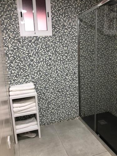a bathroom with a shower and a shelf with towels at Apartamento La Plana in Castellón de la Plana