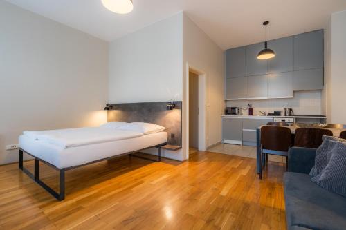 ein Wohnzimmer mit einem Bett und eine Küche in der Unterkunft EA ApartHotel Melantrich in Prag