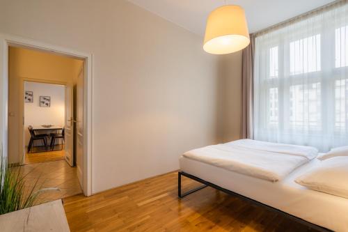 sypialnia z łóżkiem, oknem i stołem w obiekcie EA ApartHotel Melantrich w Pradze