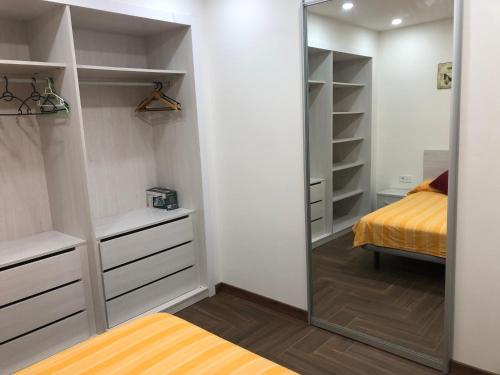 a walk in closet with a mirror and a bed at Apartamento La Plana in Castellón de la Plana