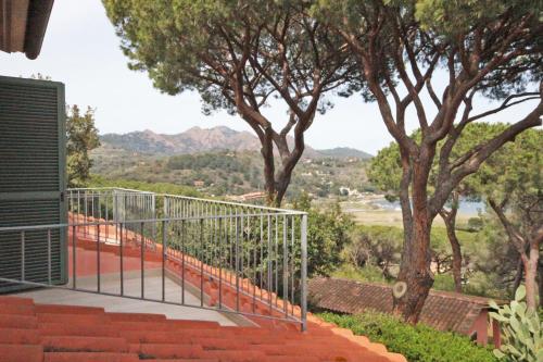 a balcony with orange stairs and trees in the background at Appartamento Il Mandorlo in Capoliveri