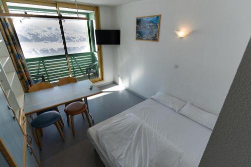 Schlafzimmer mit einem Bett, einem Schreibtisch und einem Fenster in der Unterkunft Résidence Azureva Piau Engaly in Aragnouet