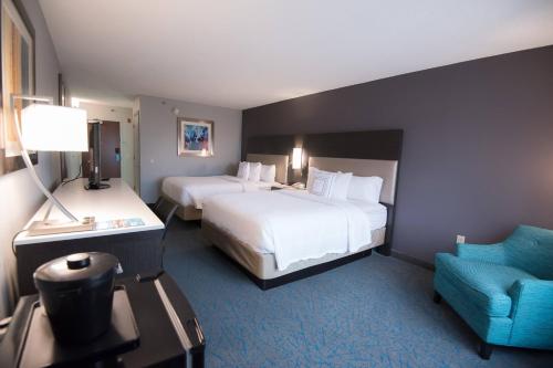 a hotel room with two beds and a chair at Fairfield Inn & Suites Atlanta Airport North in Atlanta