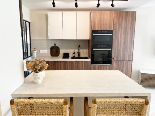 a kitchen with a table with two chairs at Le petit Berriat - Grenoble centre in Grenoble