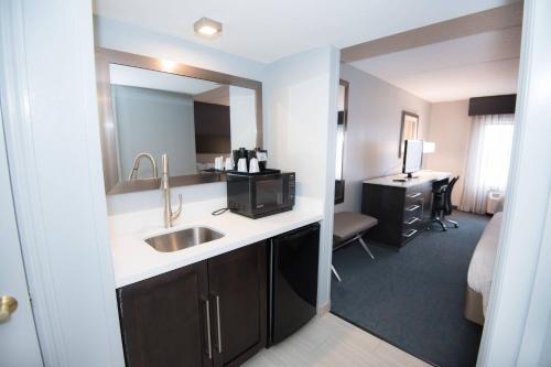 a bathroom with a sink and a room with a desk at Fairfield Inn & Suites Atlanta Airport North in Atlanta