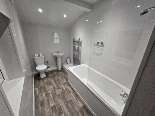 a bathroom with a tub and a toilet and a sink at 52 Wordsworth Street by Prestige Properties SA in Barrow in Furness