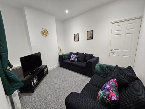 a living room with two couches and a tv at 52 Wordsworth Street by Prestige Properties SA in Barrow in Furness