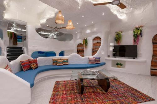 a living room with a couch and a tv at Villa Stonera by StayVista - Indoor pool, Mountain view, Outdoor firepit & A sprawling lawn for your perfect retreat in Nashik