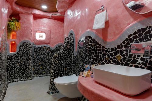 a bathroom with a red and black tiled wall at Villa Stonera by StayVista - Indoor pool, Mountain view, Outdoor firepit & A sprawling lawn for your perfect retreat in Nashik