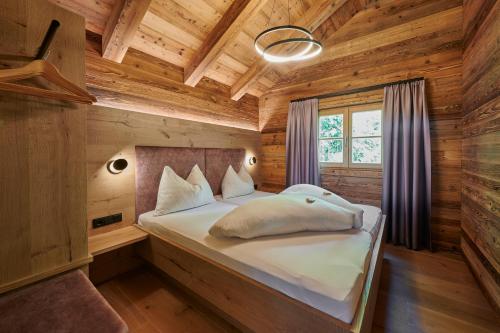 una camera da letto con un letto in una cabina di legno di Chalet´s am See a St. Wolfgang
