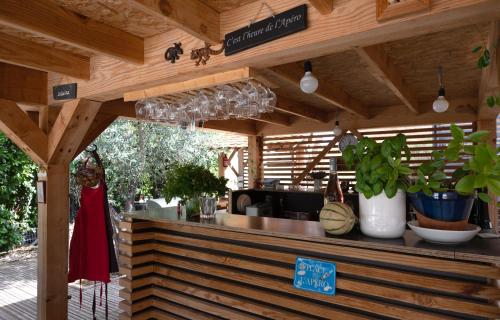 a restaurant with a counter with plants and wine glasses at Coste in Mollans-sur-Ouvèze